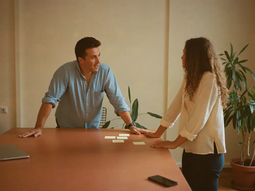 Un manager ascolta una collaboratrice che spiega come organizza il proprio lavoro